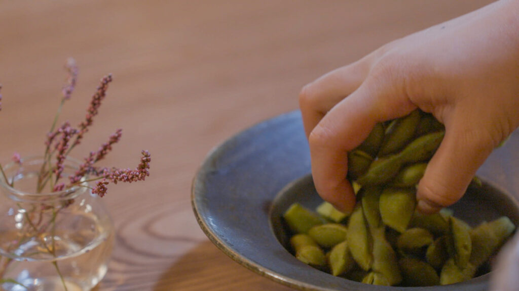 茹でた黒豆を器に盛りつけた様子。ふっくらとした黒豆の艶と、素朴な器の風合いが秋の実りを感じさせます