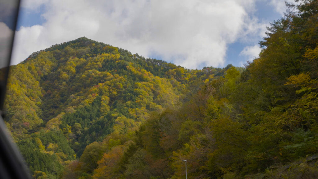車の窓を開けて見た、近くに迫る山と広がる青空。長野へ向かう道中、雨がやんで光が差し始めた瞬間の景色